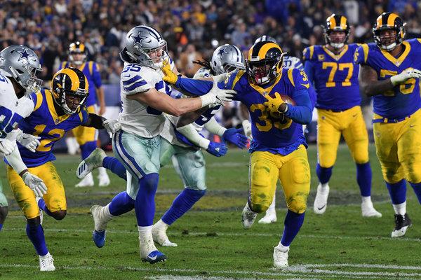 Rams running back dodges Cowboys defender in intense game.