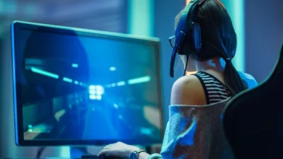 Gamer focused, playing a game on a desktop monitor.