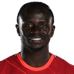 Soccer player in red jersey, smiling portrait.