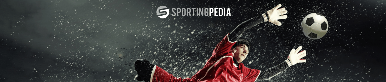 Goalkeeper diving to save a soccer ball in heavy rain; Sportingpedia logo.