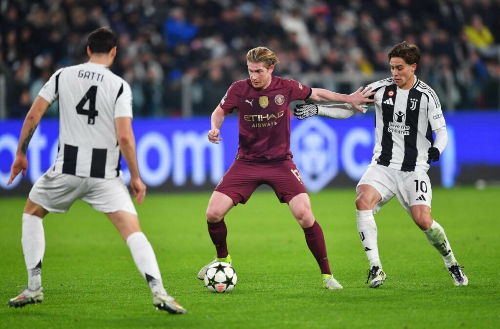 Kevin De Bruyne surrounded by 2 Juventus players