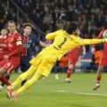 Liverpool's goalkeeper Alisson saves a shot from a PSG player