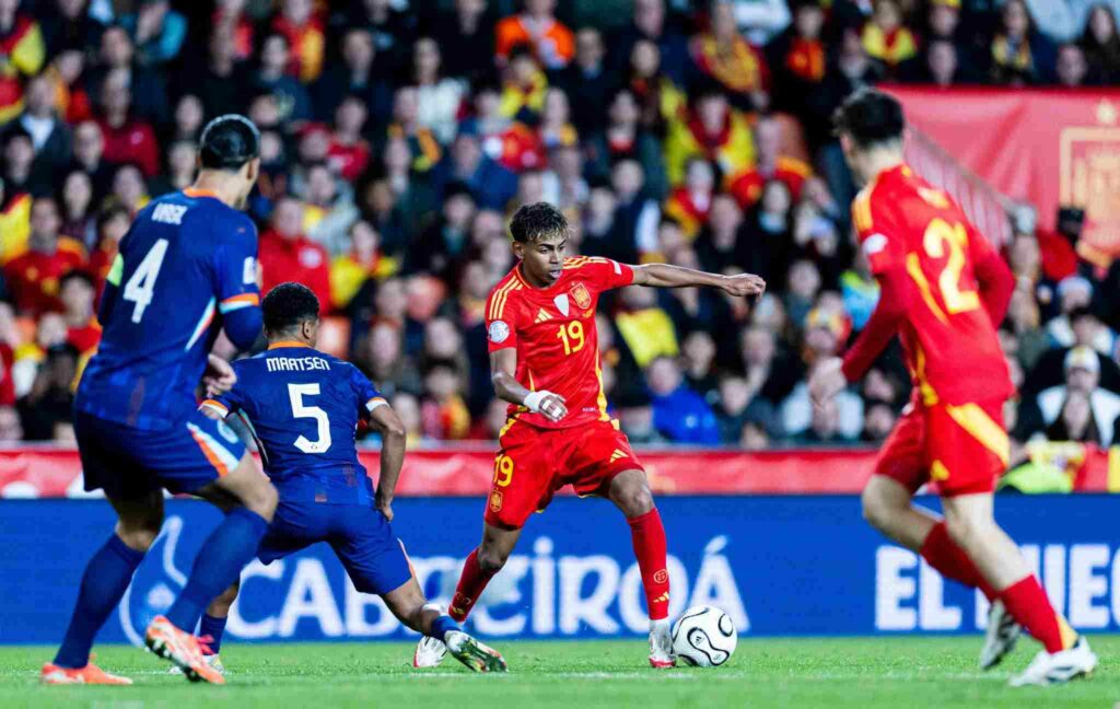 Lamine Yamal preparing to take a shot in front of Yan Maatsen and Virgil Van Dijk
