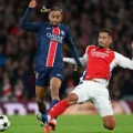 William Saliba tackles Bradley Barcola in the Champions League group stage match between Arsenal and PSG