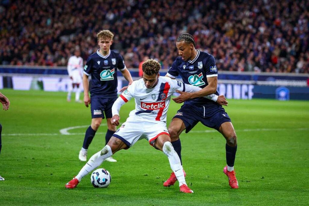 Desire Doue protecting the ball, surrounded by Dunkerque players