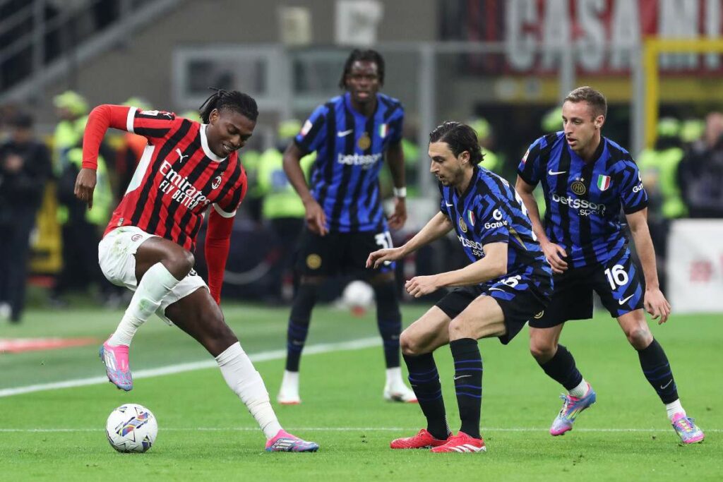 Rafael Leao dribbles with the ball as 3 Inter players watch