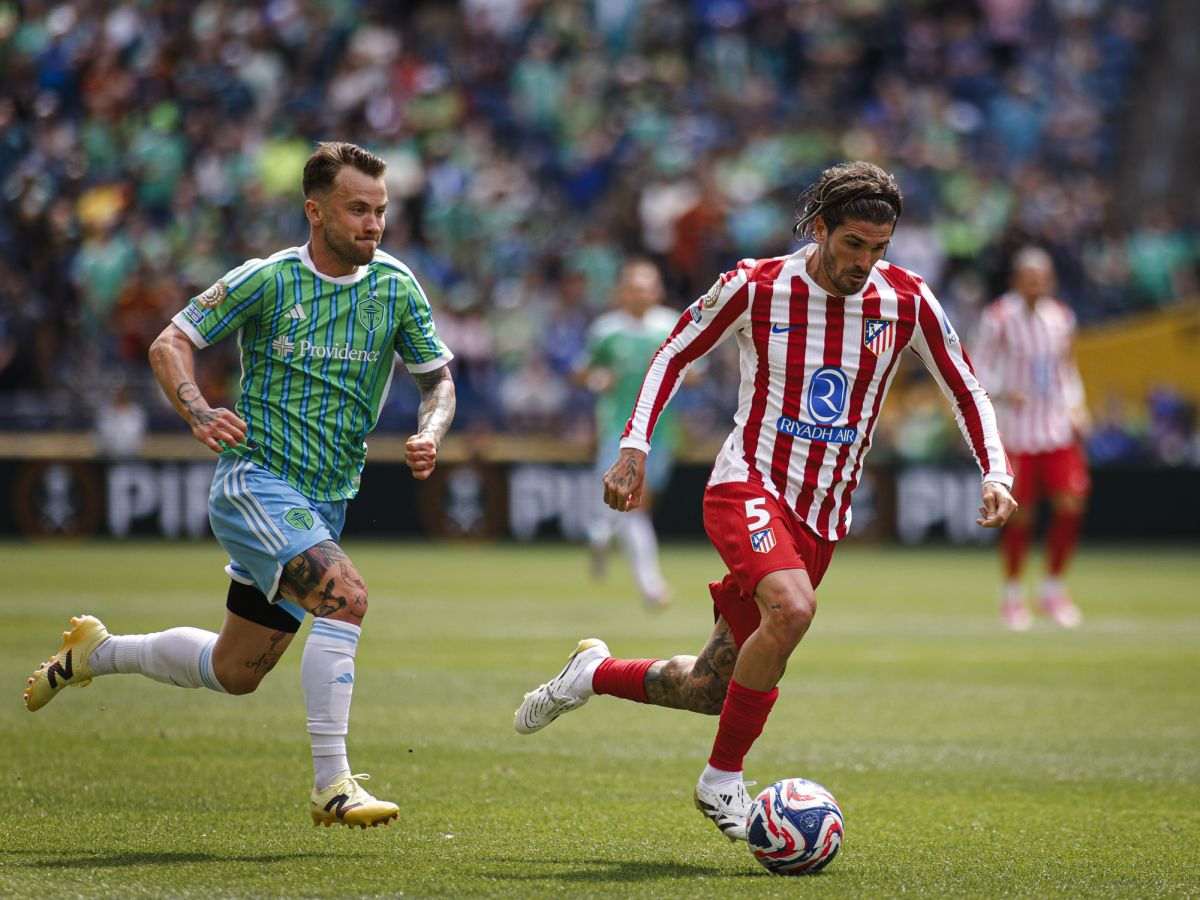 Rodrigo de Paul runs away with the ball from a Seattle Sounder player