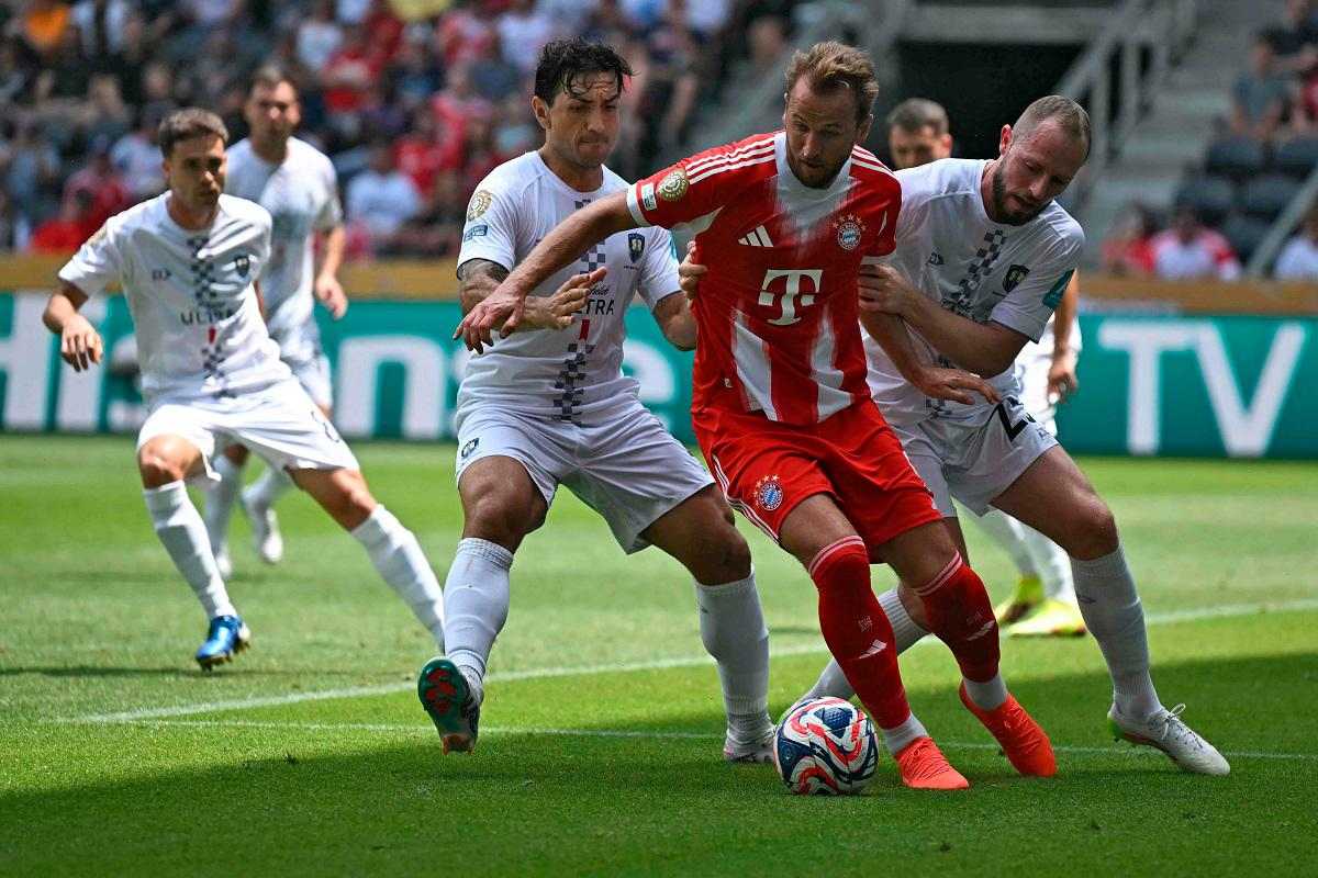 2 Auckland players trying to take the ball from Harry Kane