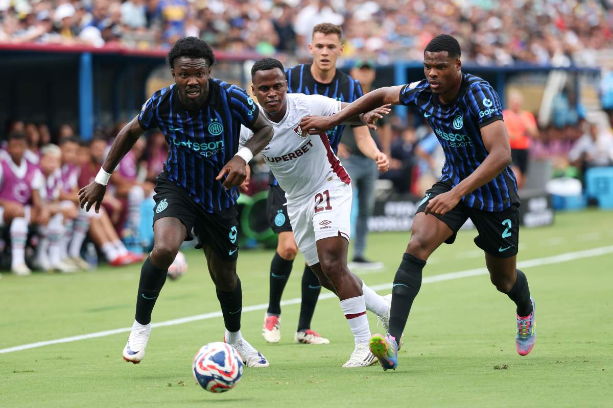 Fluminense player trying to go past Marcus Thuram and Denzel Dumfries of Inter