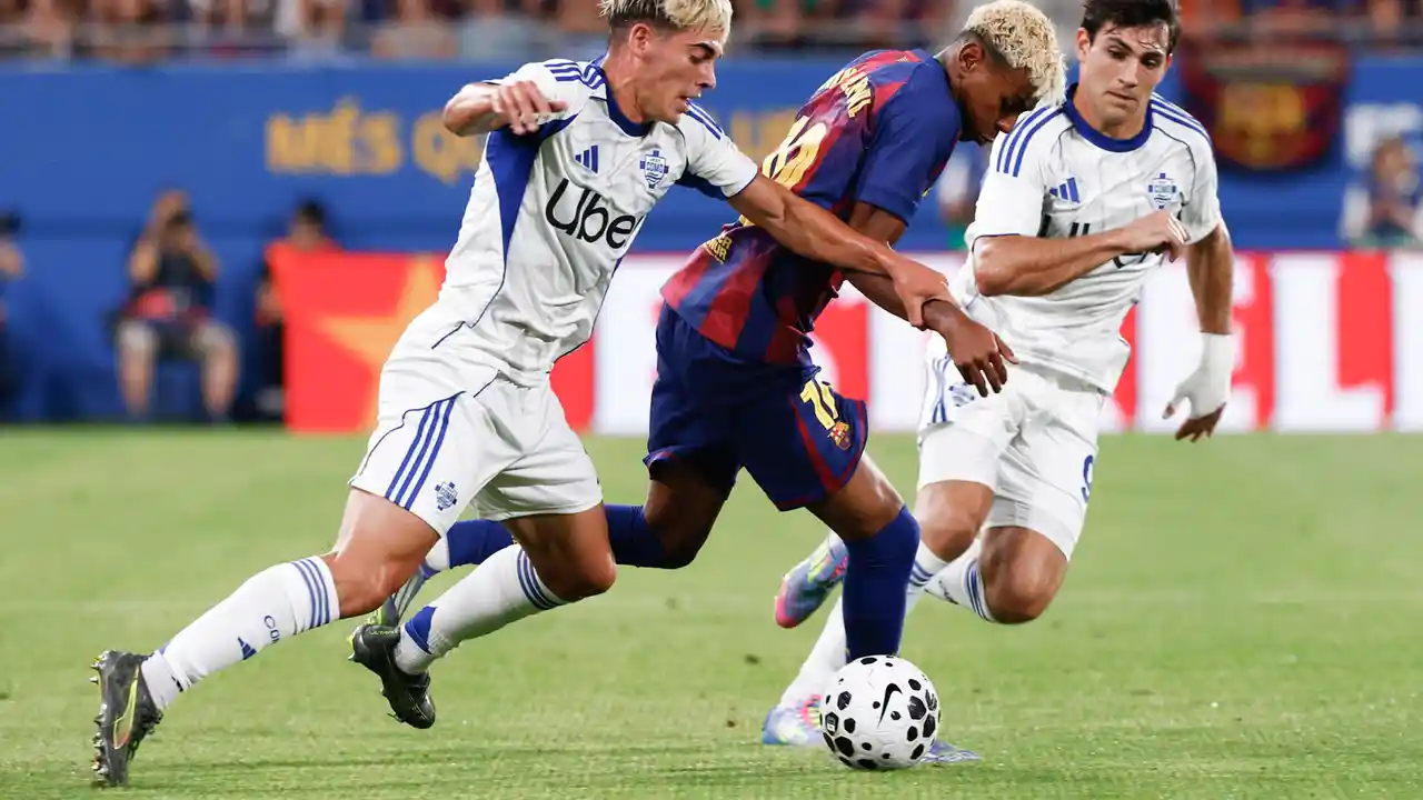 Lamine Yamal dribbles between two Como players