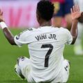 Vinicius Junior sitting on the ground with raised hands