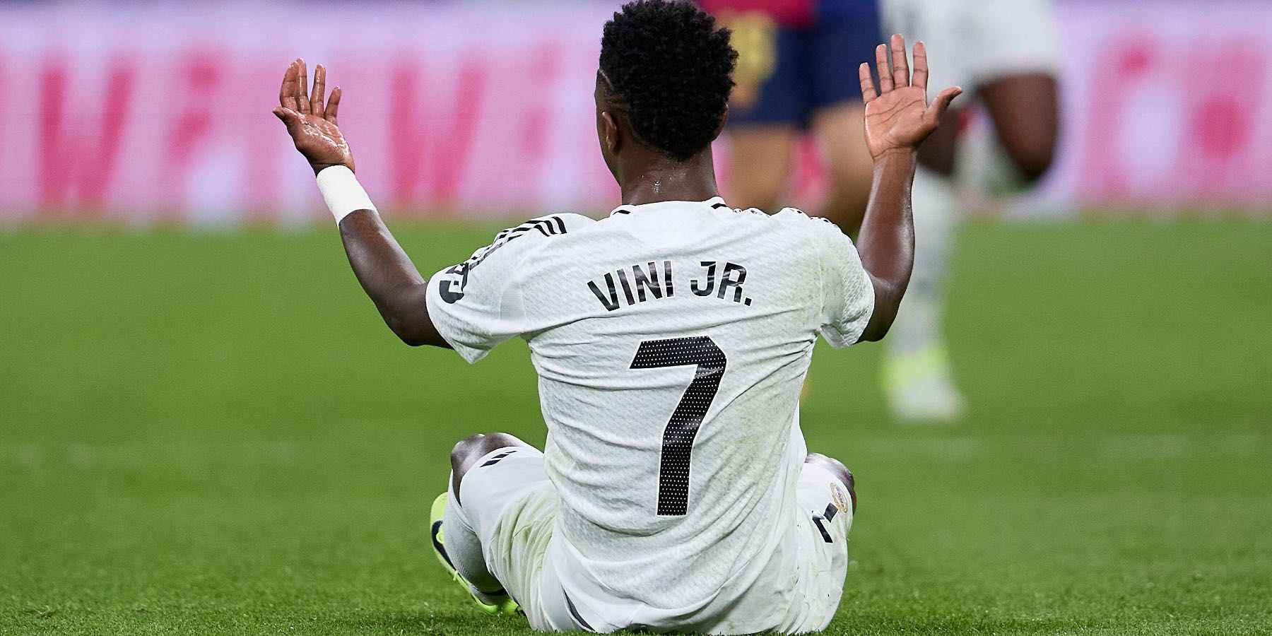 Vinicius Junior sitting on the ground with raised hands