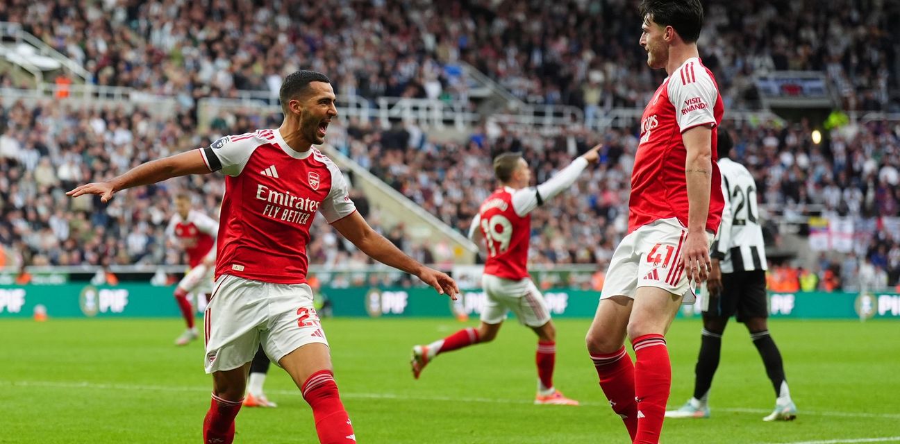 Arsenal players celebrate after scoring late against Newcastle