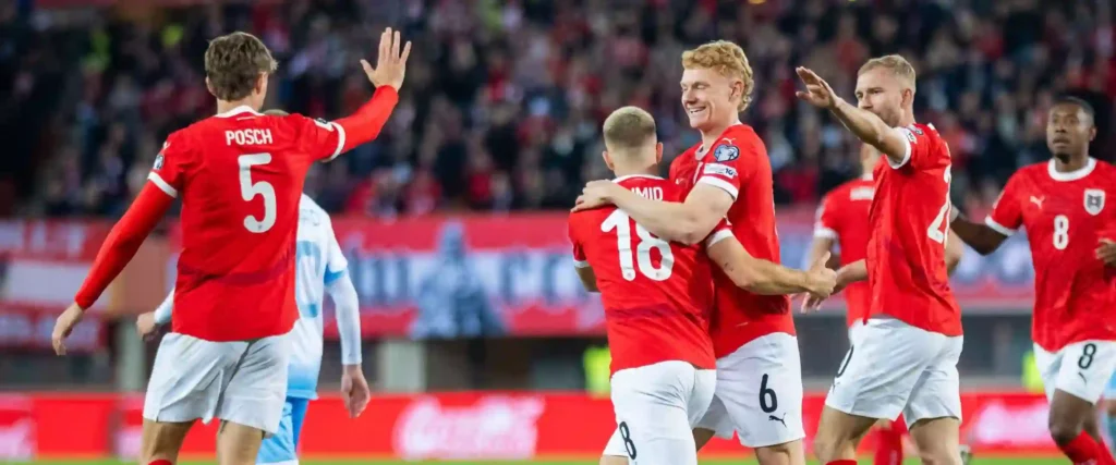 Austria players congratulate one another after scoring against San Marino