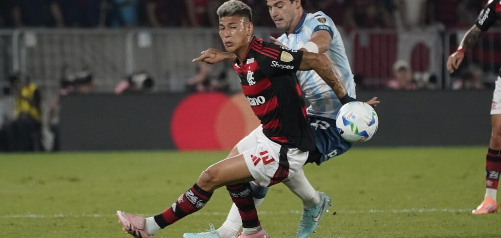 Flamengo player trying to escape from a Racing opponent