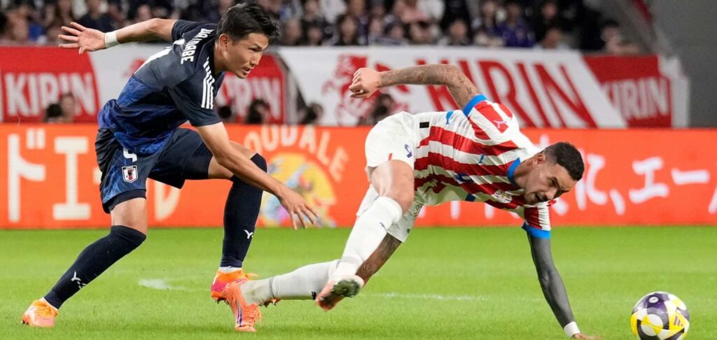 Players from Japan and Paraguay in a battle for the ball