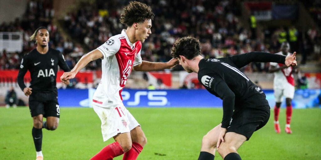 Monaco player trying to dribble past an opponent from Tottenham