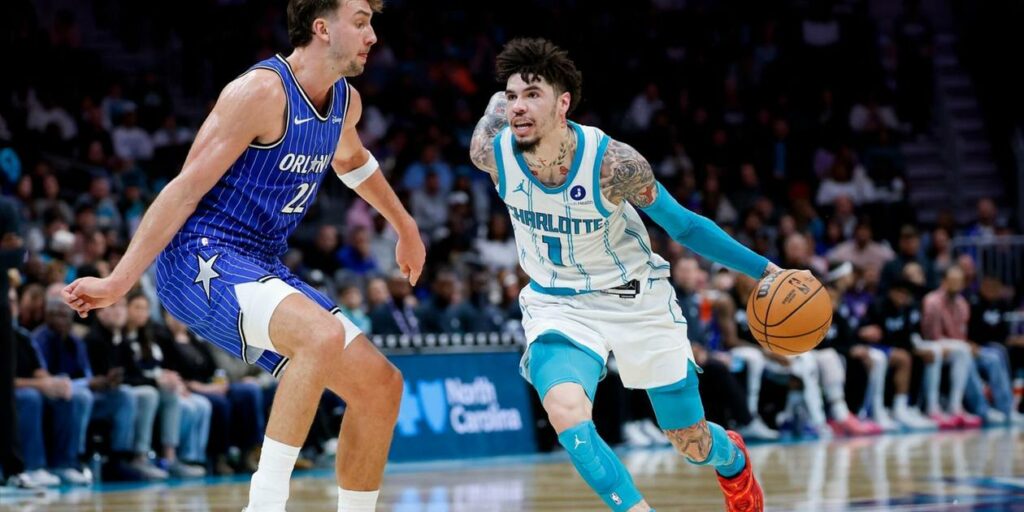 LaMelo Ball dribbles the ball guarded by Franz Wagner