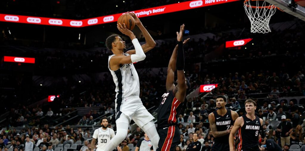 Victor Wembanyama shoots at the basket, guarded by Bam Adebayo