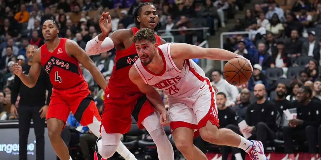 Alperen Sengun dribbles the ball under pressure from Toronto Raptors player