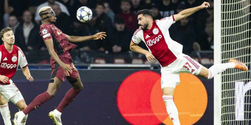 Victor Osimhen gets first to the ball before Ajax defender