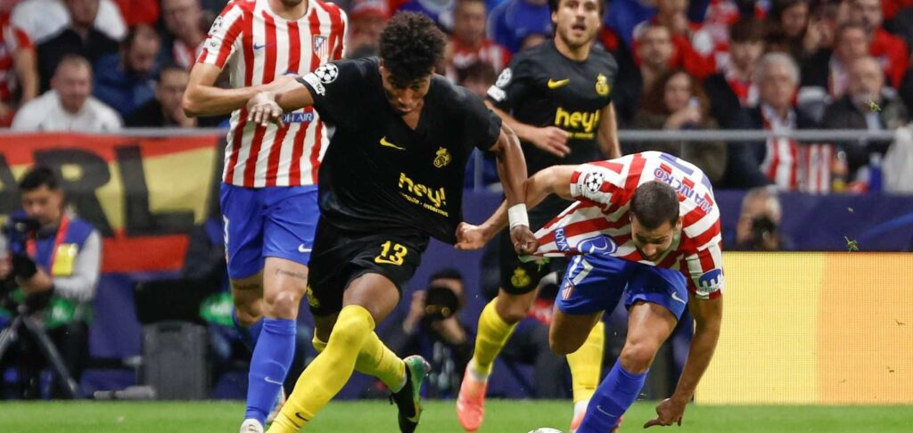 Union SG player tries to escape a challenge from Atletico Madrid footballer
