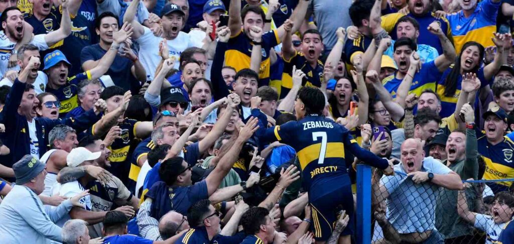 Exequiel Zeballos celebrates with the fans after scoring against River Plate