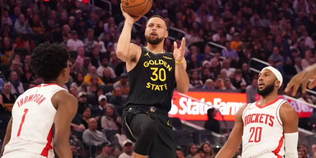 Amen Thompson and Josh Okogie watch as Steph Curry shoots at Houston Rockets' basket