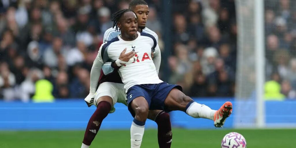 Tottenham striker Mathys Tel protecting the ball from an opposition player