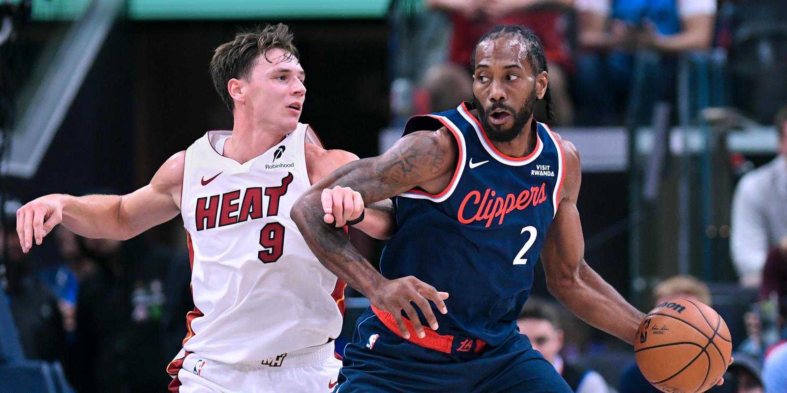 Kahwi Leonard dribbles the ball under pressure from a Miami Heat player