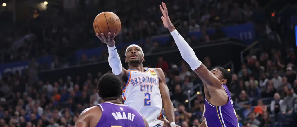 Shai Gilgeous-Alexander attempts a lay-up as Marcus Smart and Rui Hachimura watch