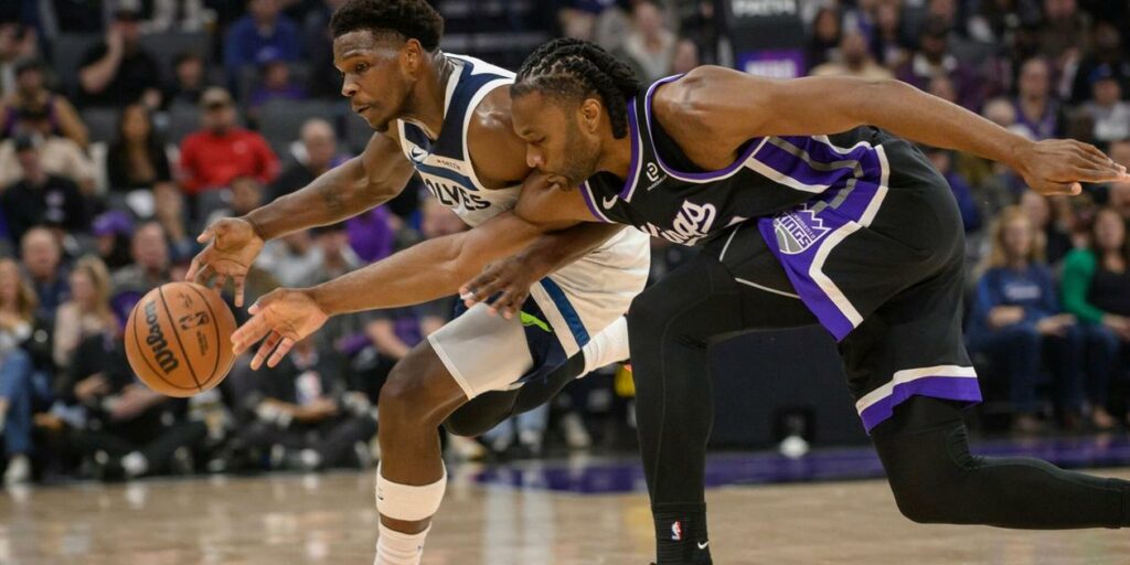 Anthony Edwards battles for the ball with a Sacramento Kings player