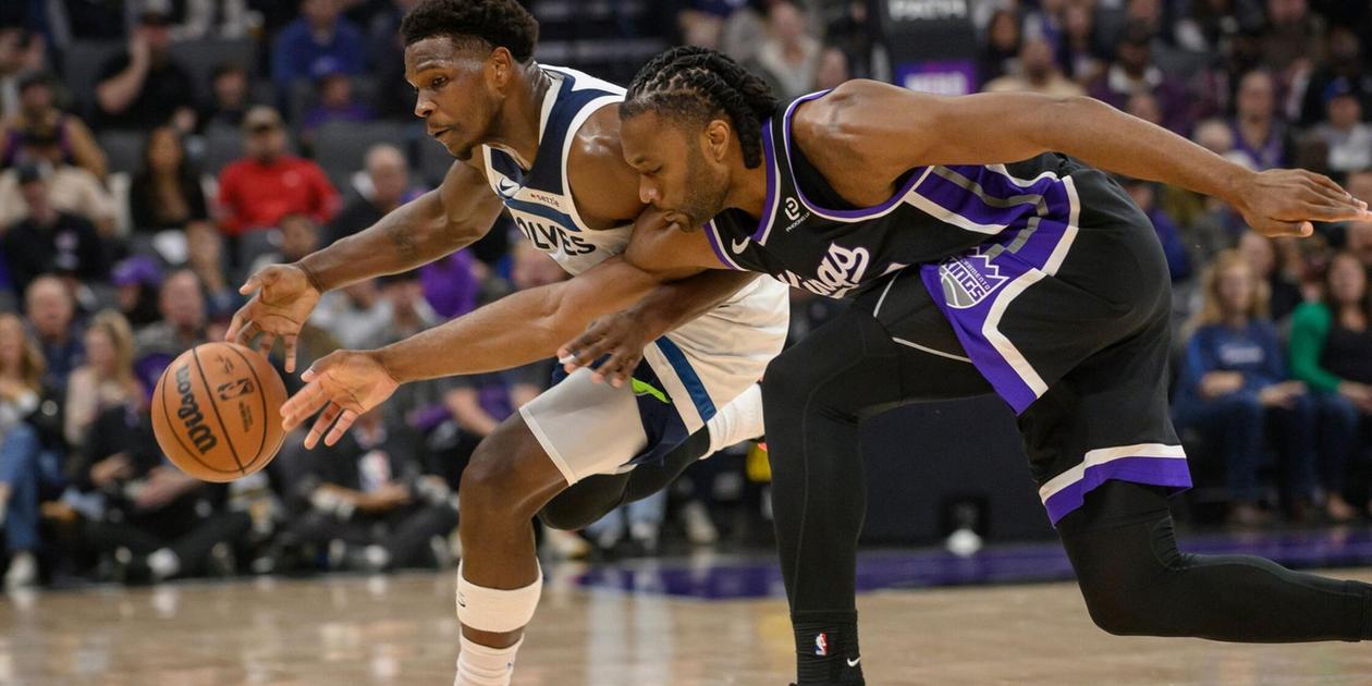 Anthony Edwards battles for the ball with a Sacramento Kings player