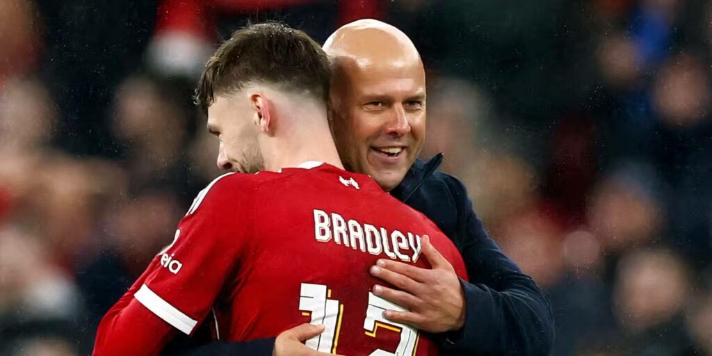 Liverpool manager Arne Slot hugging defender Conor Bradley