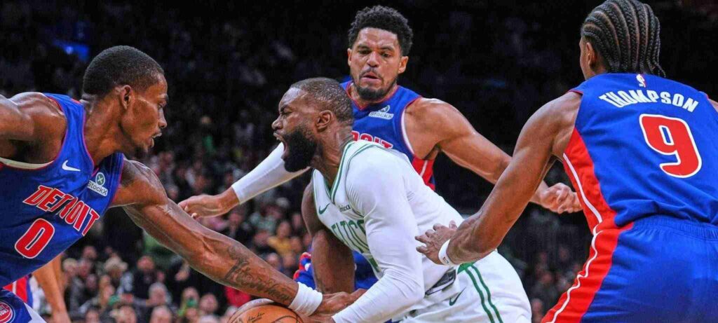 Three Detroit Pistons players trying to stop Jaylen Brown
