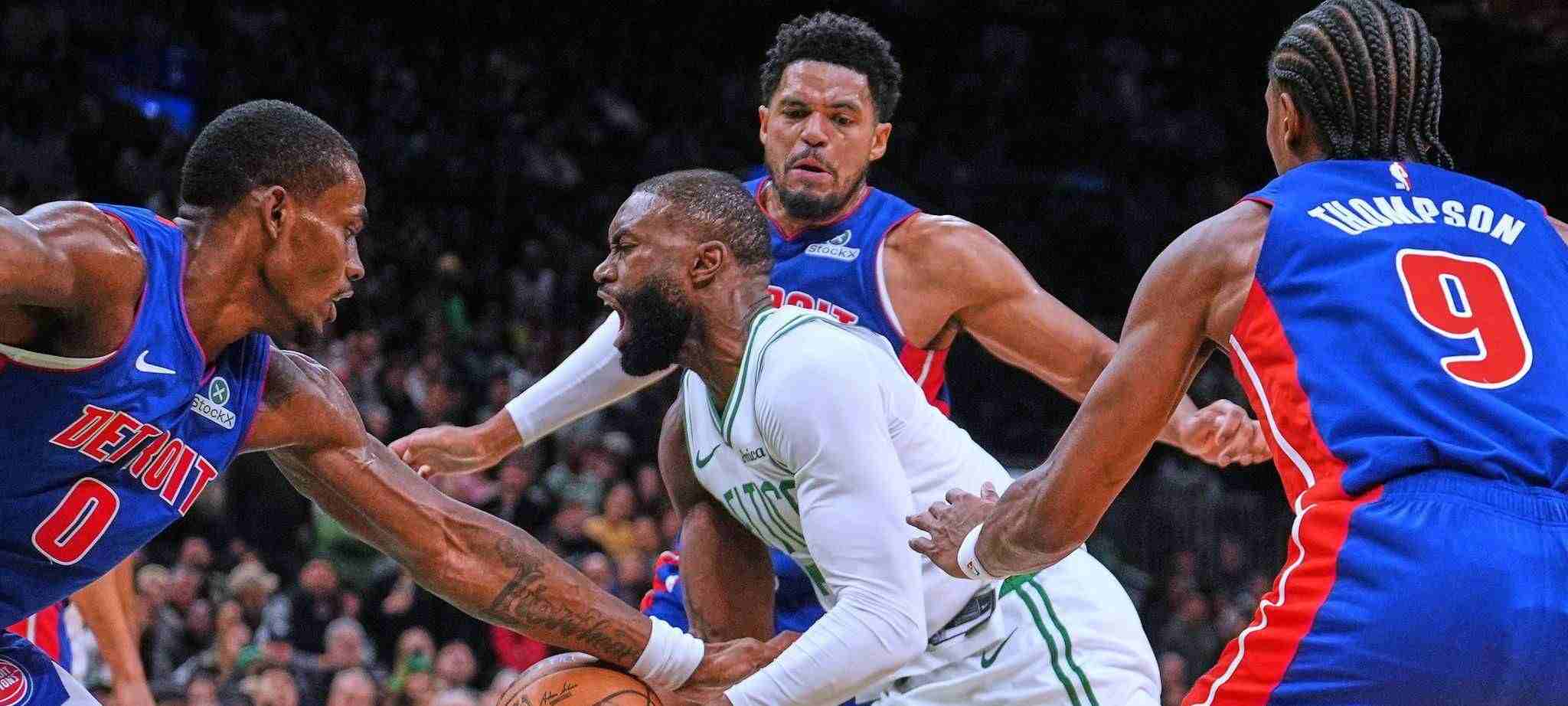 Three Detroit Pistons players trying to stop Jaylen Brown