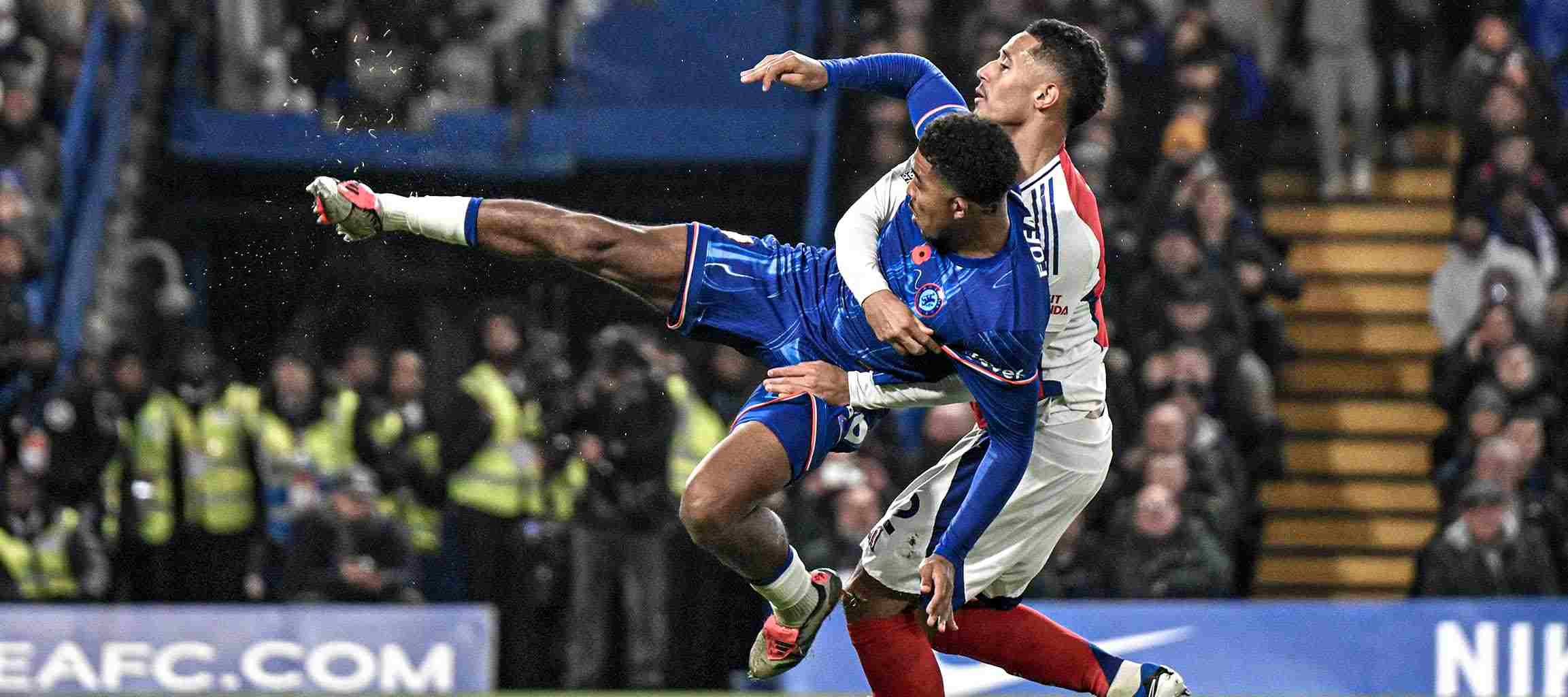 Arsenal player lifting Chelsea player in the air