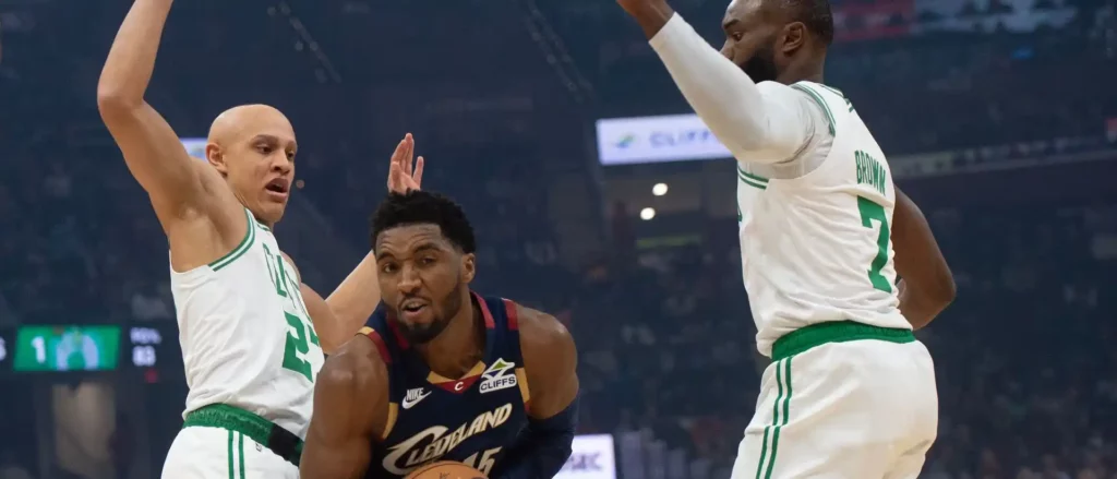 Donovan Mitchell between 2 Boston Celtics players