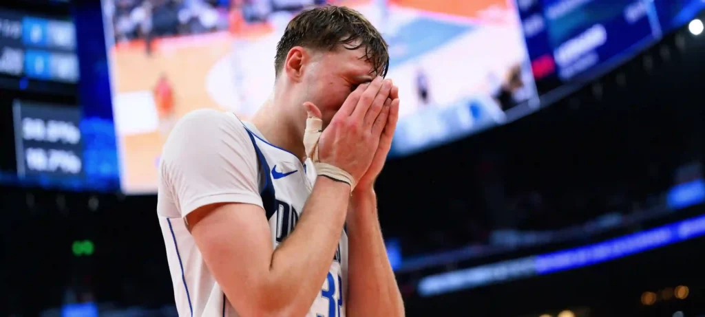 Dallas Mavericks forward Cooper Flagg holding his face