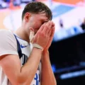 Dallas Mavericks forward Cooper Flagg holding his face