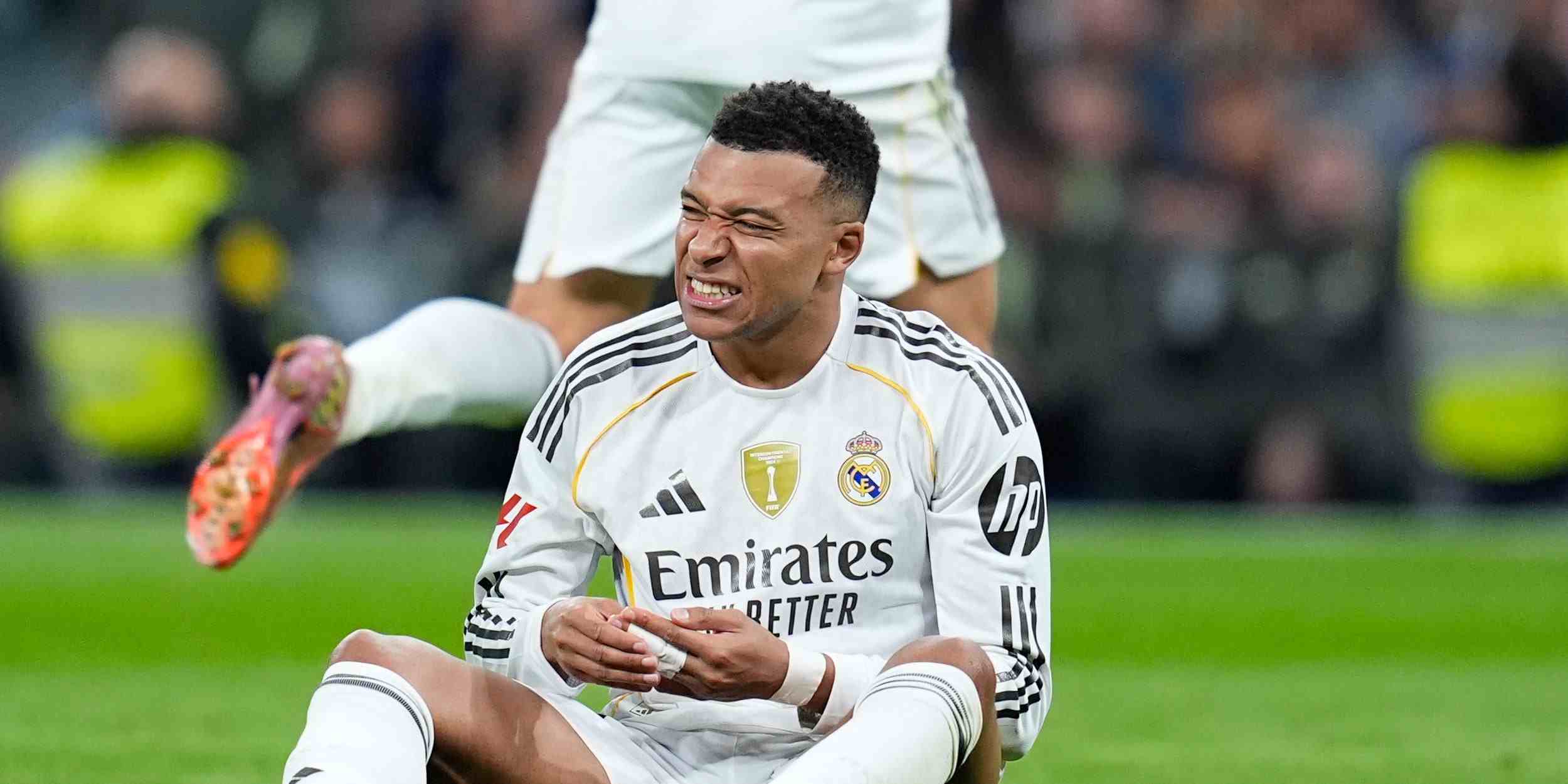 Kylian Mbappe sitting on the ground with a possible injury