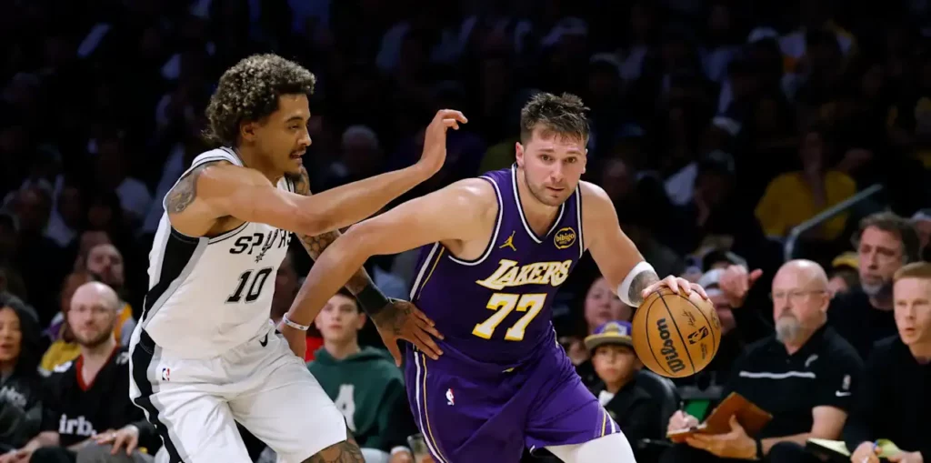 Jeremy Sochan trying to stop Luka Doncic