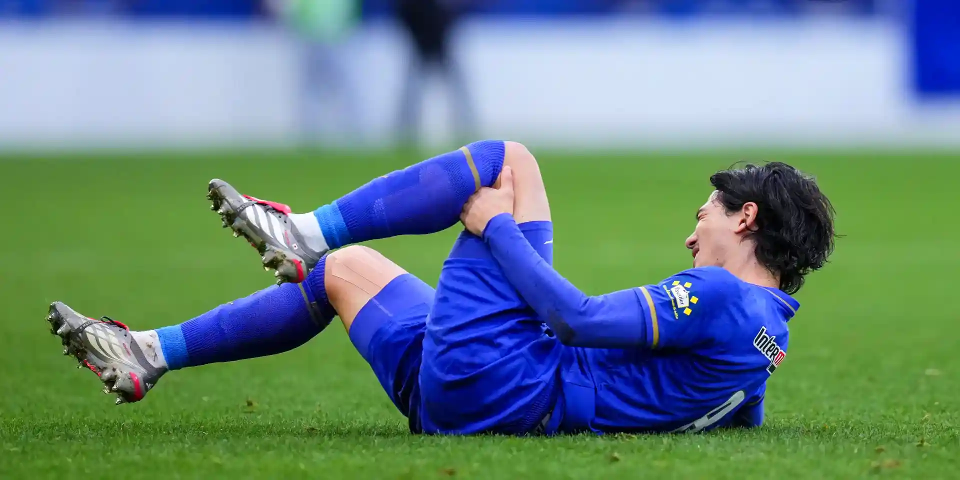 Takumi Minamino holding his leg after getting injured