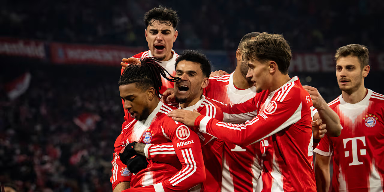Bayern Munich players congratulate Michael Olise after scoring against Wolfsburg