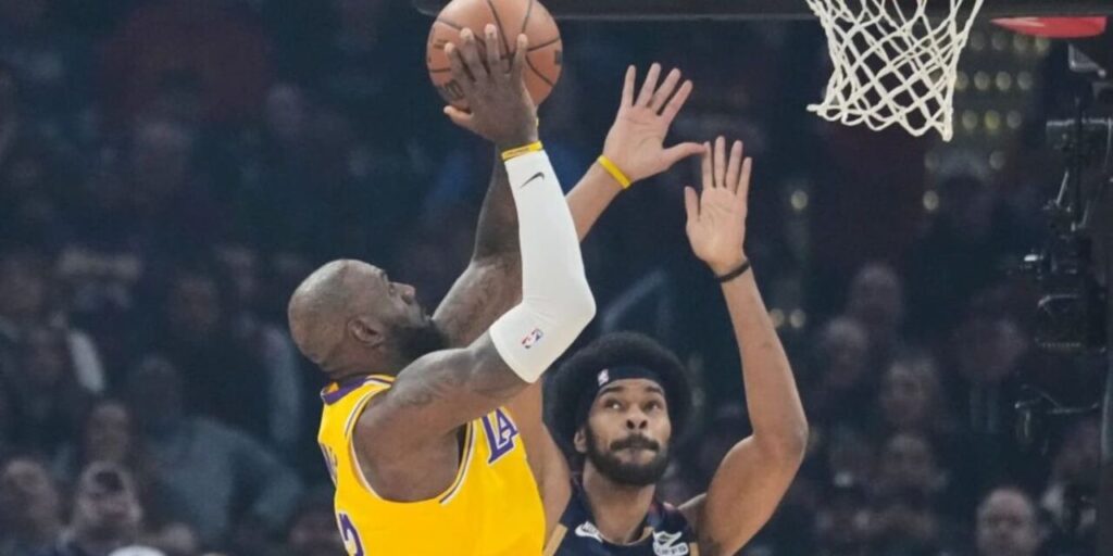 LeBron James trying to score in Cleveland's basket despite Jarrett Allen's defence