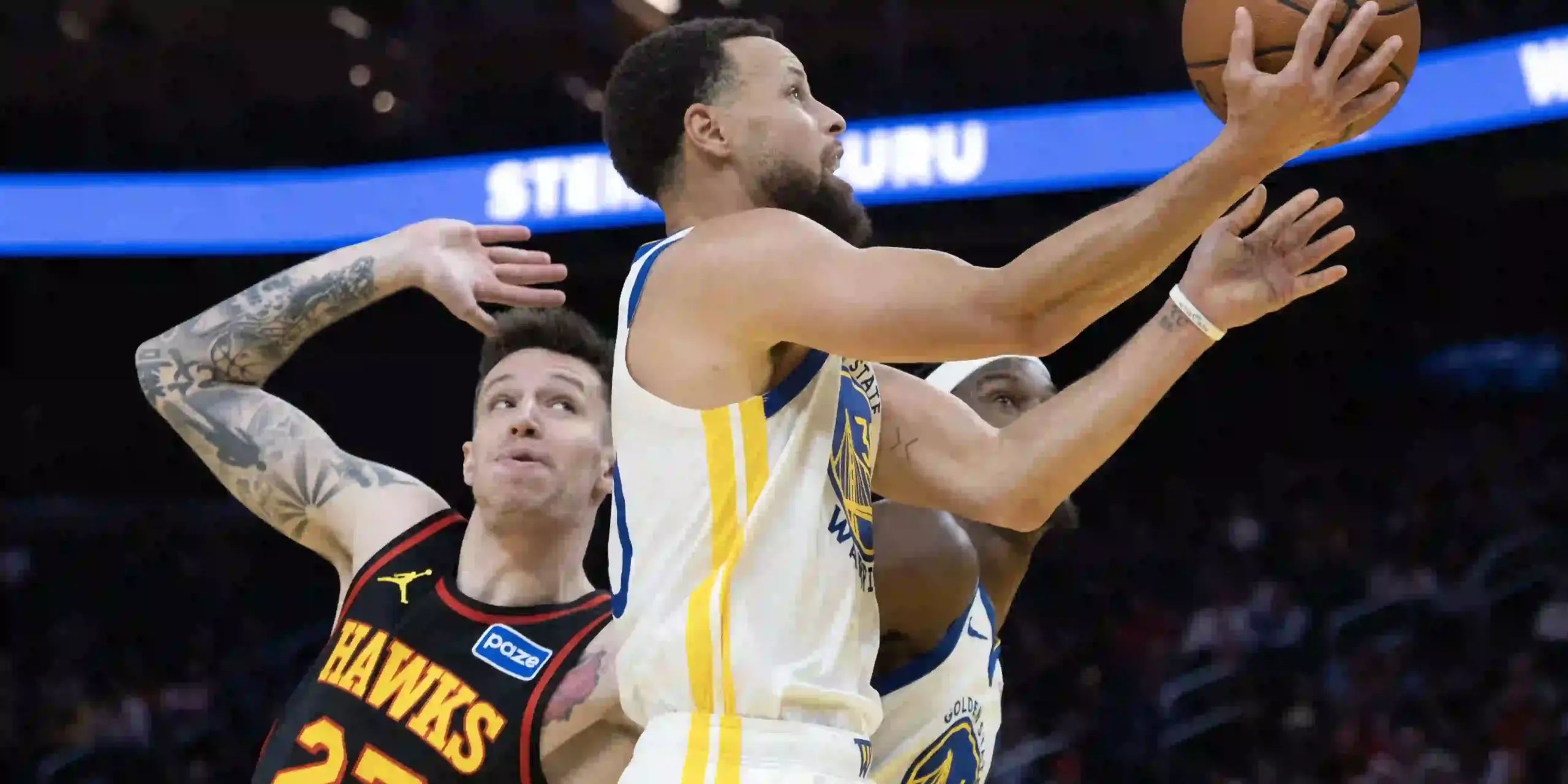 Steph Curry tries to score in Atlanta Hawks' basket