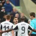 Referee brandishes yellow card in the match between Newcastle and PSV