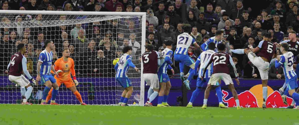 Aston Villa and Brighton players jumping for a high ball