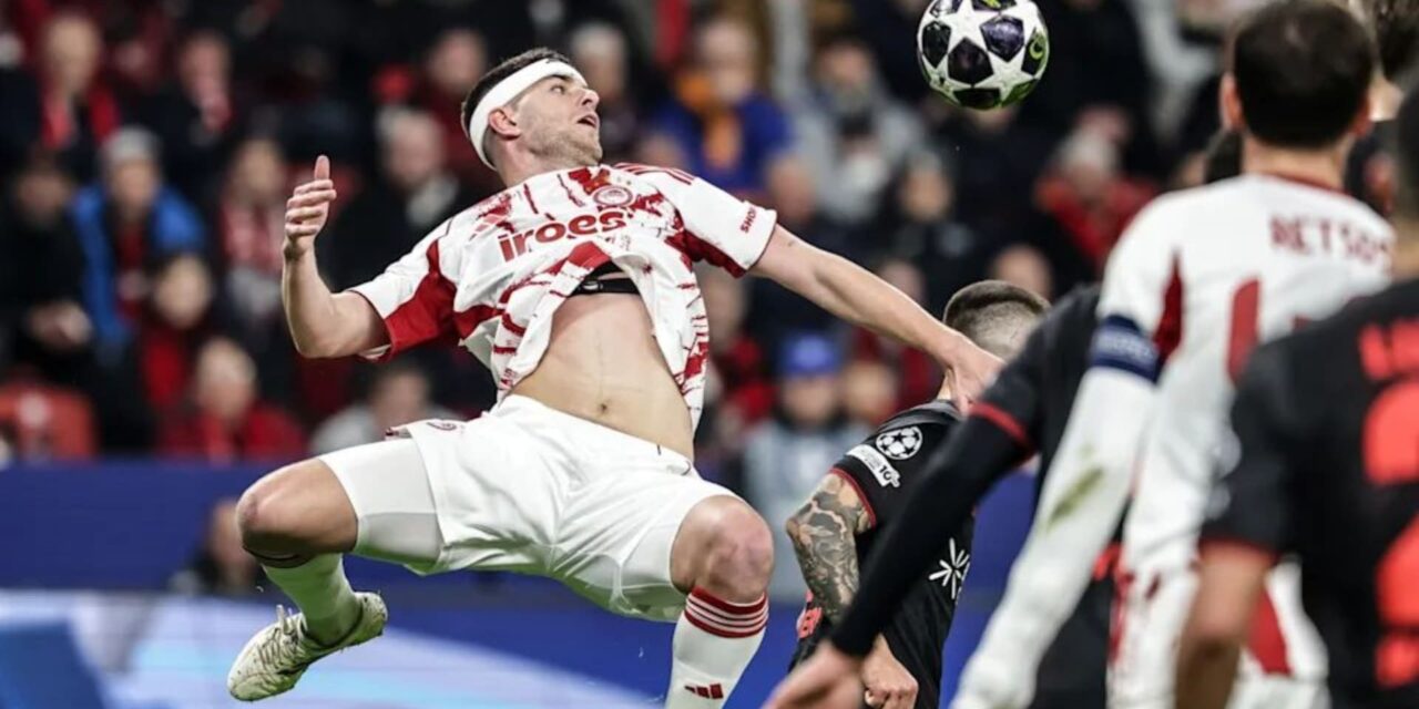 Olympiacos player jumping to meet a cross during the match with Bayer Leverkusen