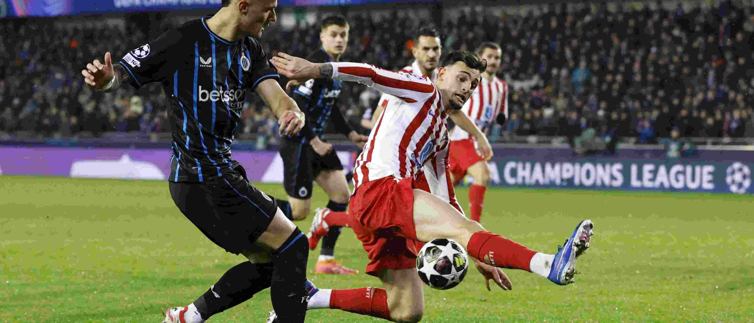 Atletico Madrid player trying to block a cross from a Club Brugge opponent